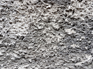 Gray relief texture of wall. Embossed concrete with expressive pattern. Decoration of exterior and interior. Styreets buildings. Artistic object. The lava of the volcano is silvery.