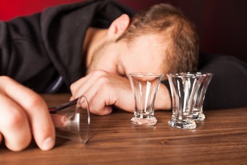 A drunk man is sleeping on a table