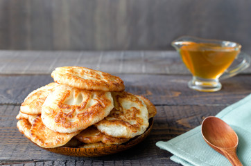Russian-style fritters on dark wooden background