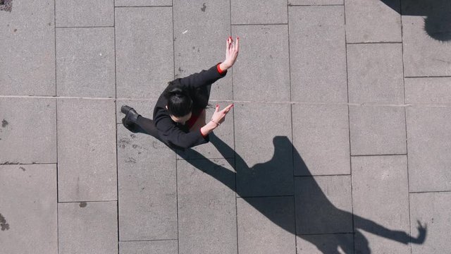 View from above of sexy female dancer in Vogue and Waacking dance style dancing in the city with urban background.