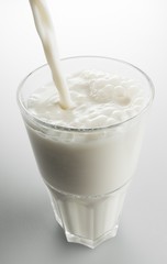Pouring white milk in Glass