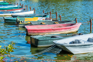 Fototapeta na wymiar Row of old vintage colorful boats on the lake of Enghien les Bains near Paris, France
