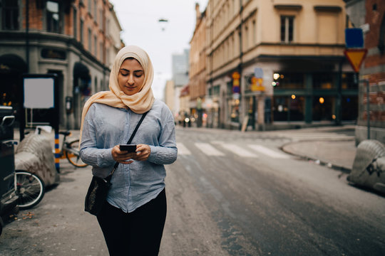 Woman walking with smartphone in street