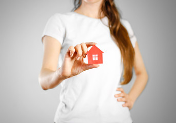 A girl holds the icon of the house. Key ring red house