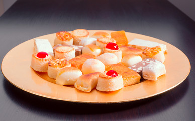 group of marzipan in golden tray isolated on black board
