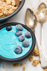 blue yogurt with berries in the black bowl