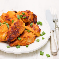 fried chicken with green onion on white plate on wooden background