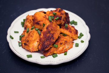 fried chicken on white plate on wooden background