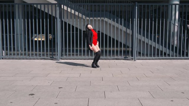 Sexy female dancer in Vogue and Waacking dance style dancing in the city with urban background.