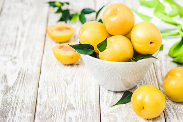 Fresh yellow plums on wooden board. Selective focus, space for text.