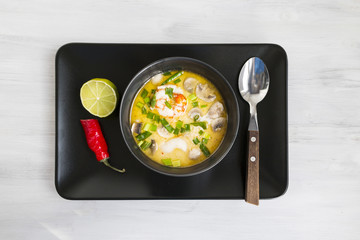 Tom Yum soup in plack bowl. Top view. Copy space. Closeup.