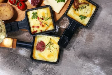 Fotobehang Delicious traditional Swiss melted raclette cheese on diced boiled or baked potato. © beats_