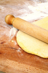 Fototapeta na wymiar How to prepare Italian fettuccine, roll out the dough, vertical