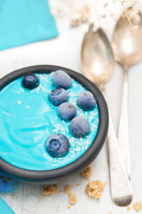 Obraz na płótnie Canvas blue yogurt with berries in the black bowl