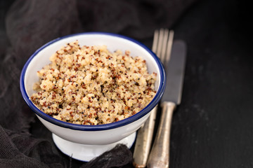 boiled quinoa in white bowl on black background