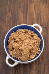 cereals in white blue bowl on brown background