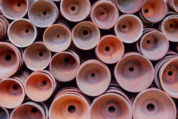 Fototapeta premium Rows of clay plant pots stacked neatly on their sides.