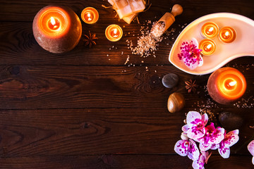 Spa concept with chocolate and candles on a wooden background.