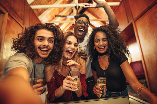 Group of friends taking selfie at night club party