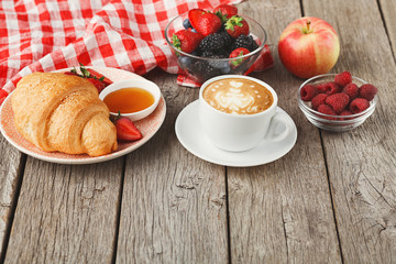 Continental breakfast with croissants and berries on natural woo