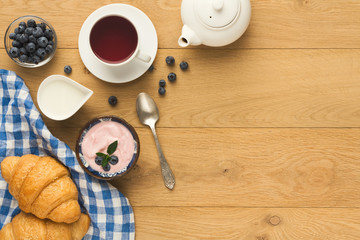 Continental breakfast with croissants and berries on natural woo