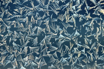 Frost patterns on window glass on a cold winter morning.