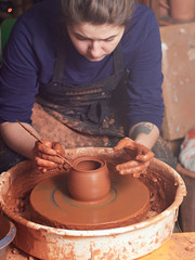 production process of pottery. Forming a clay teapot on a potter's wheel.