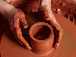 Fototapeta na wymiar production process of pottery. Forming a clay teapot on a potter's wheel.