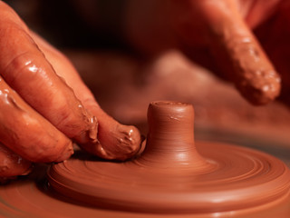 production process of pottery. Forming the clay cover of the kettle on the potter's wheel.