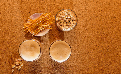 Two glasses of dark beer and a plate of snacks are on the table. The view from the top.