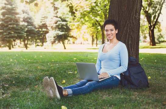 Handsome woman with laptop outdoors