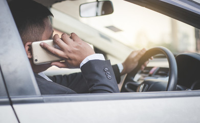 Businessman using smartphone in car.