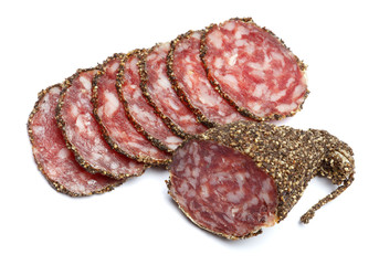 Dried organic salami sausage covered with pepper on white background