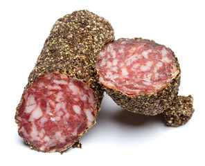 Dried organic salami sausage covered with pepper on white background