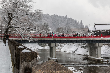 Tourists on Nagabashi  bridge in snowy day in Takayama,Gifu,Japan.