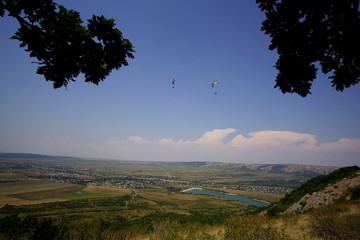 Two paragliders soar high in the sky