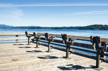 Wooden Chairs on a Pier Facing the Ocean. Campbell River, BC, Canada.
