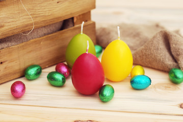 Obraz na płótnie Canvas Easter still life, candle eggs on rustic Background and textile background.