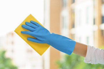 Housekeeper cleaning mirror with yellow cloth.