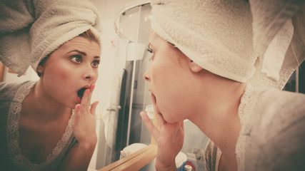 Woman looking at her reflection in mirror