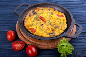 Omelette on an iron frying pan. Dish for the restaurant