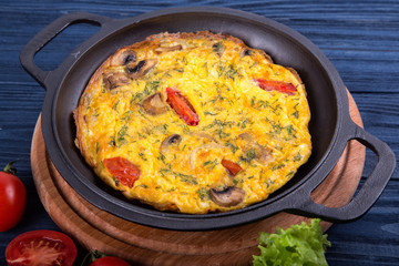 Omelette on an iron frying pan. Dish for the restaurant