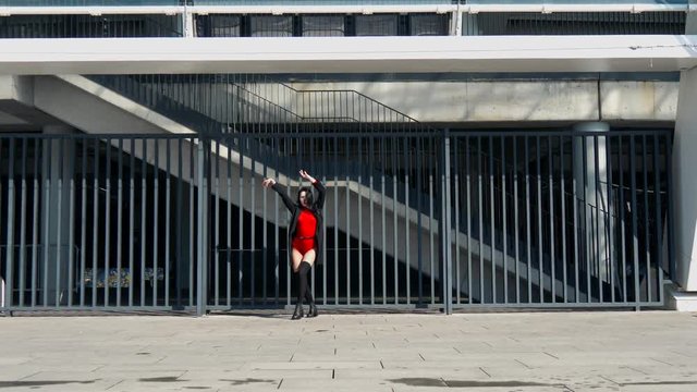 Sexy female dancer in Vogue and Waacking dance style dancing in the city with urban background.