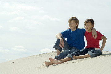 Fototapeta na wymiar boys sitting on the sand