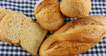 Various breads and toasts top view on blue plaid fabric