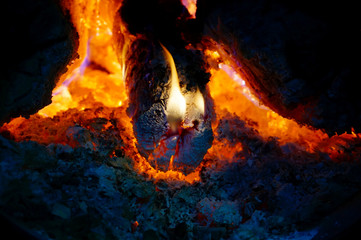 Fire in the fireplace, tongues of flame from a burning log on fire