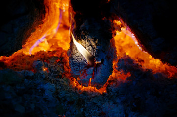 Fire in the fireplace, tongues of flame from a burning log on fire