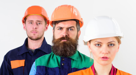 Serious workers concept. Woman and men in hard hats