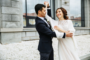 Bride whirls around groom's hand on the city square