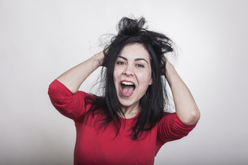 Verrückte Frau in einer glücklichen Situation zerzaust sich ihre schwarzen langen Haare